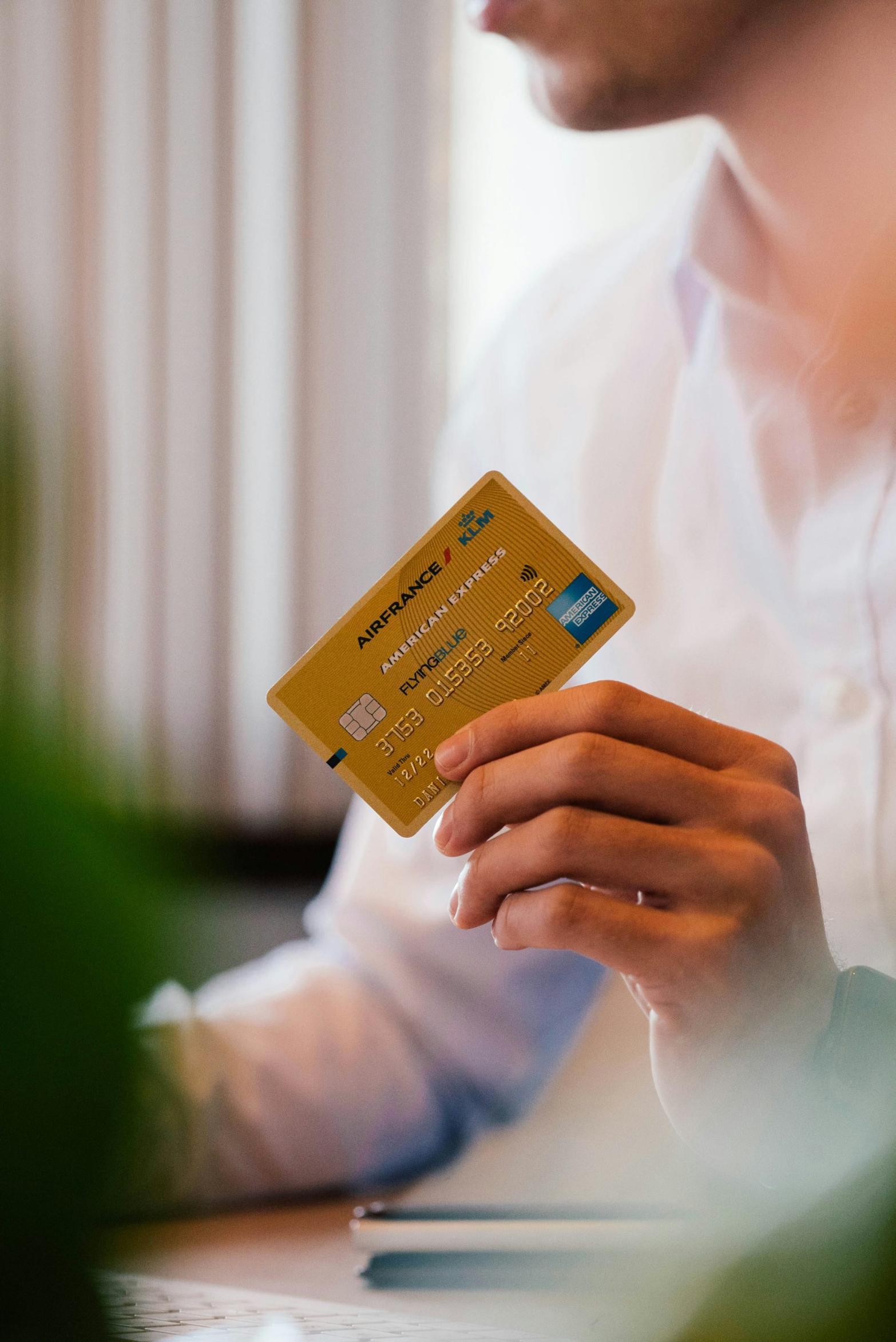 A person holding a gold credit card, preparing for an online payment