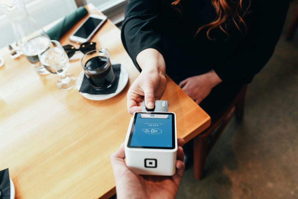 A customer making a card payment using a small device