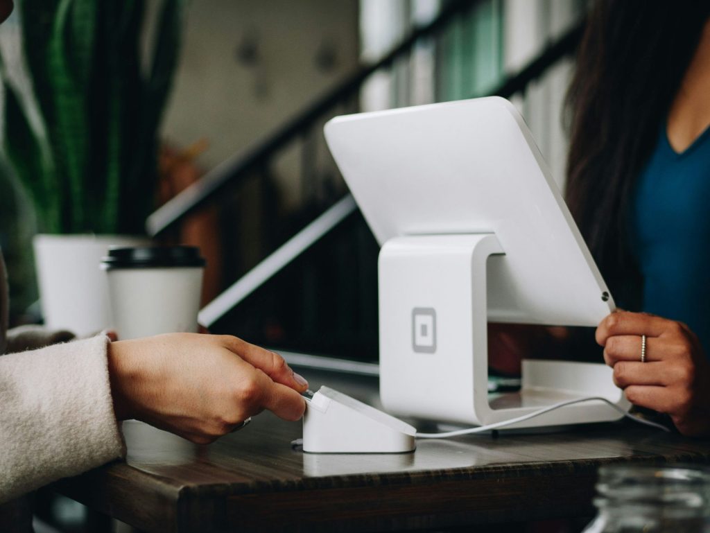 A close-up of a customer paying using a card with a modern POS system